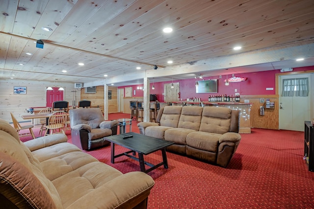 carpeted living area featuring a dry bar, wooden ceiling, wooden walls, and recessed lighting