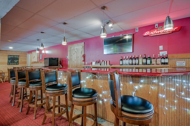 bar with a dry bar, carpet, a drop ceiling, and decorative light fixtures