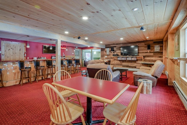 carpeted dining space with baseboard heating, recessed lighting, wood ceiling, and wooden walls