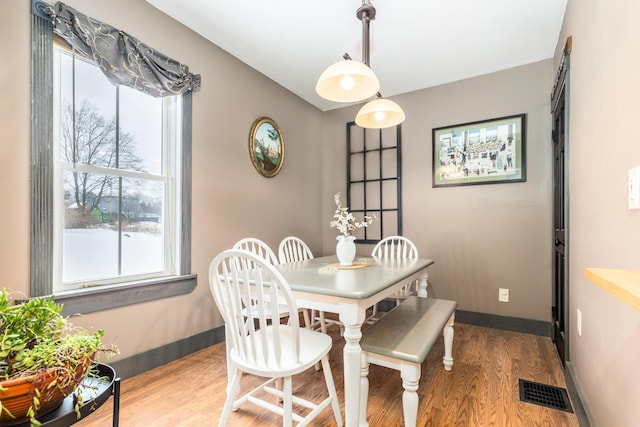 dining space featuring baseboards, visible vents, and wood finished floors