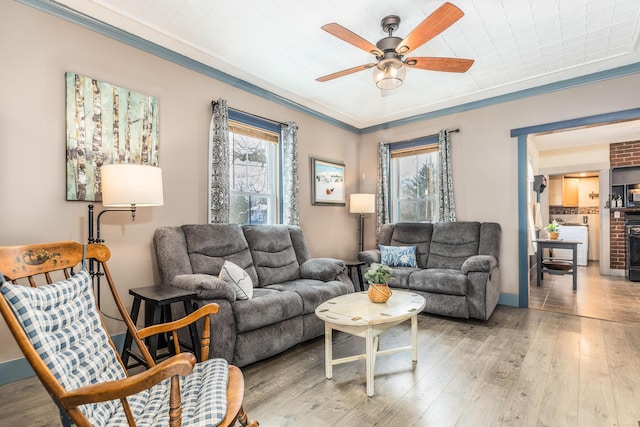 living area with ornamental molding, hardwood / wood-style flooring, and a wealth of natural light