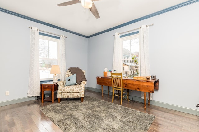 living area featuring ornamental molding, wood finished floors, and a wealth of natural light