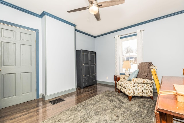 living area with visible vents, baseboards, a ceiling fan, ornamental molding, and wood finished floors