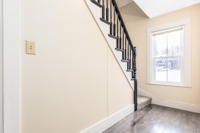 staircase with wood finished floors and baseboards