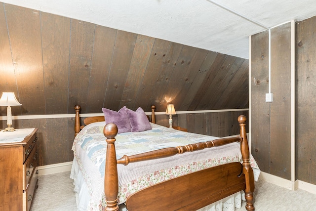 bedroom featuring carpet floors, wooden walls, and lofted ceiling