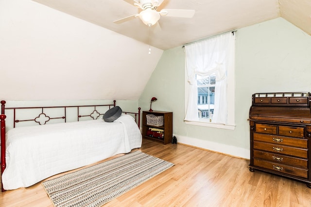 bedroom featuring lofted ceiling, ceiling fan, baseboards, and wood finished floors