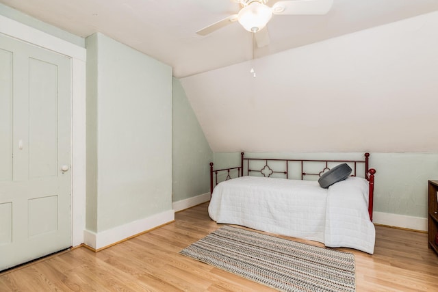 bedroom featuring lofted ceiling, ceiling fan, baseboards, and wood finished floors