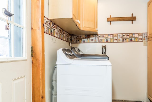 clothes washing area with washer and clothes dryer and cabinet space