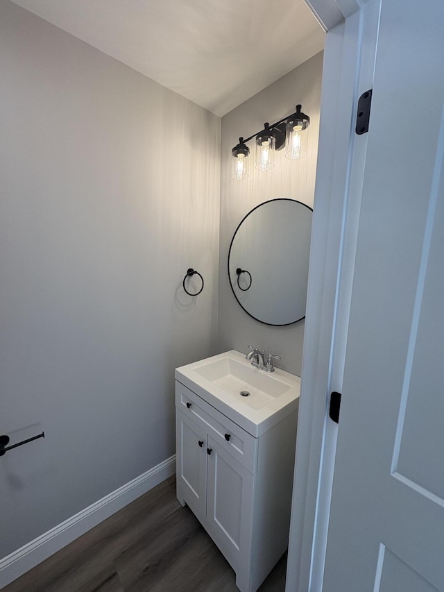 bathroom featuring wood finished floors, vanity, and baseboards