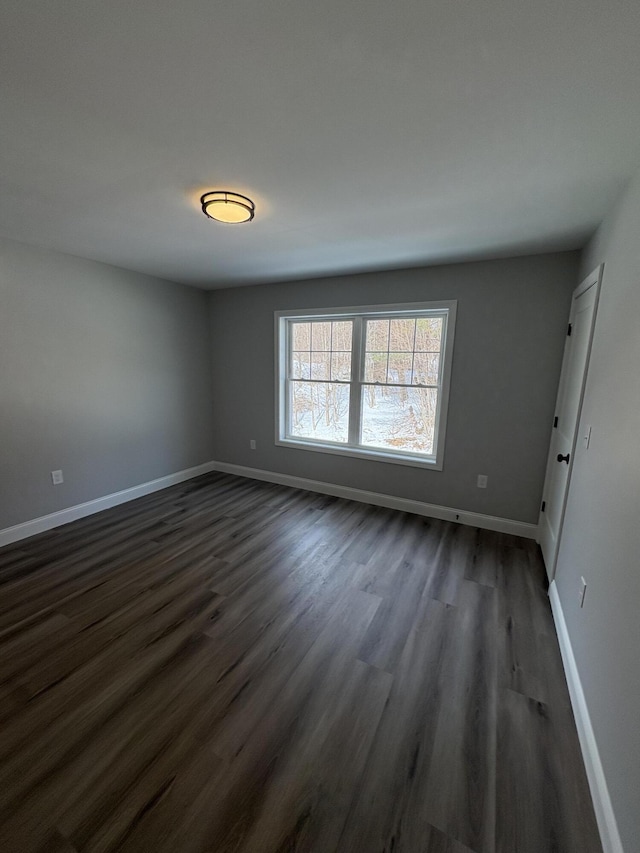 interior space with dark wood-type flooring and baseboards