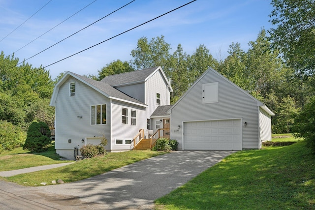 view of front of property with an attached garage, roof with shingles, driveway, and a front lawn