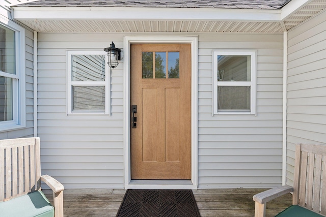 doorway to property featuring roof with shingles