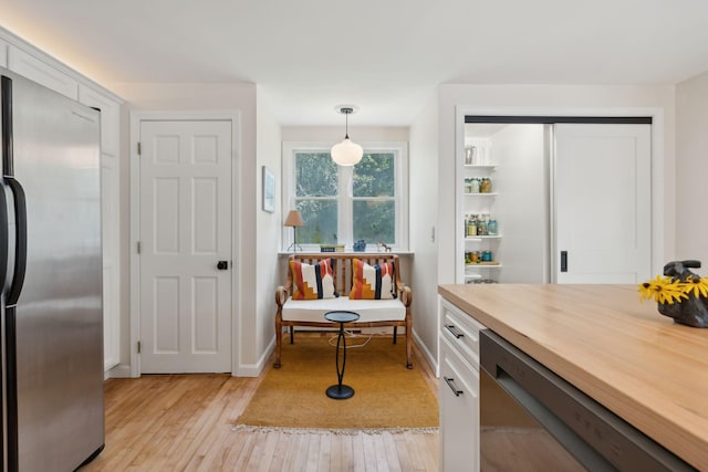 interior space featuring wine cooler, baseboards, and light wood finished floors