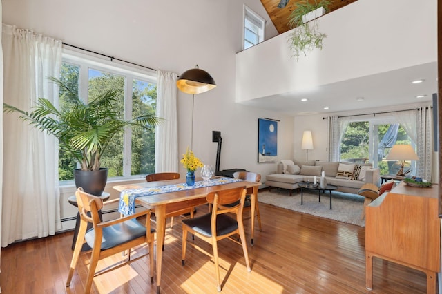 dining space with a high ceiling and hardwood / wood-style floors