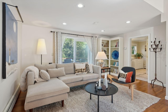 living area with baseboards, baseboard heating, wood finished floors, and recessed lighting