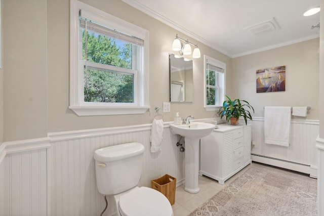 bathroom featuring crown molding, toilet, a baseboard heating unit, wainscoting, and tile patterned flooring