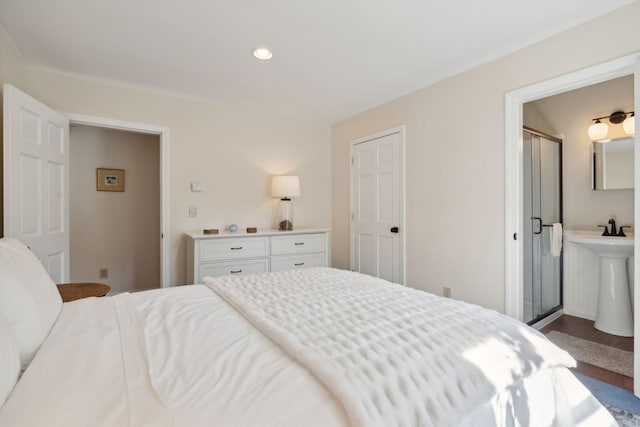 bedroom featuring wood finished floors, a sink, and recessed lighting