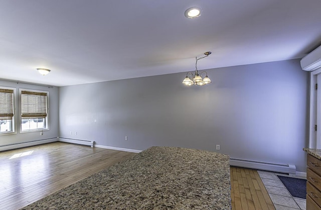 interior space featuring a chandelier, a baseboard radiator, baseboards, a wall mounted AC, and dark wood finished floors