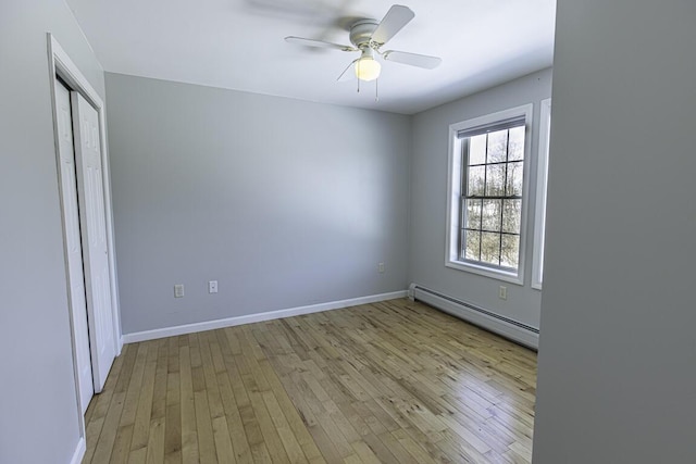 unfurnished bedroom featuring light wood-type flooring, a baseboard radiator, a closet, and baseboards