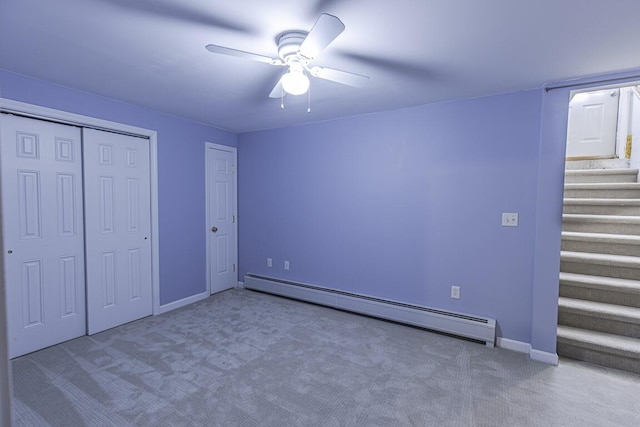 unfurnished bedroom featuring baseboards, a ceiling fan, carpet, baseboard heating, and a closet