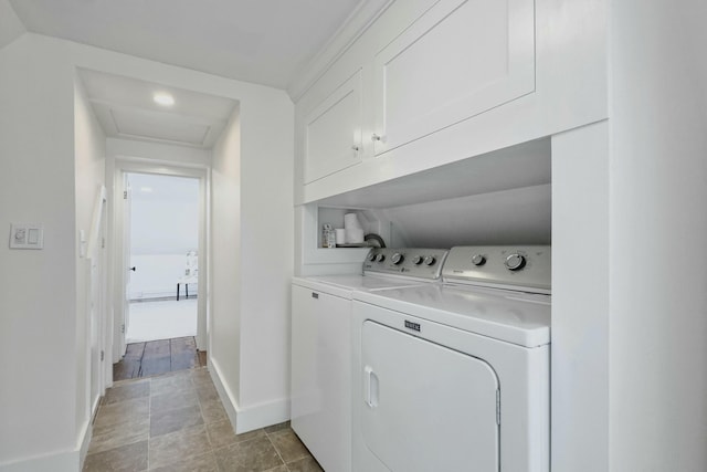 laundry area with cabinet space, baseboards, and washer and clothes dryer