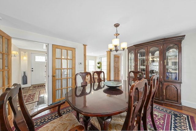 dining room featuring dark wood-type flooring, visible vents, baseboards, and an inviting chandelier