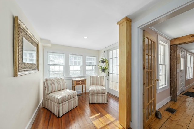 living area featuring visible vents, baseboards, and wood finished floors