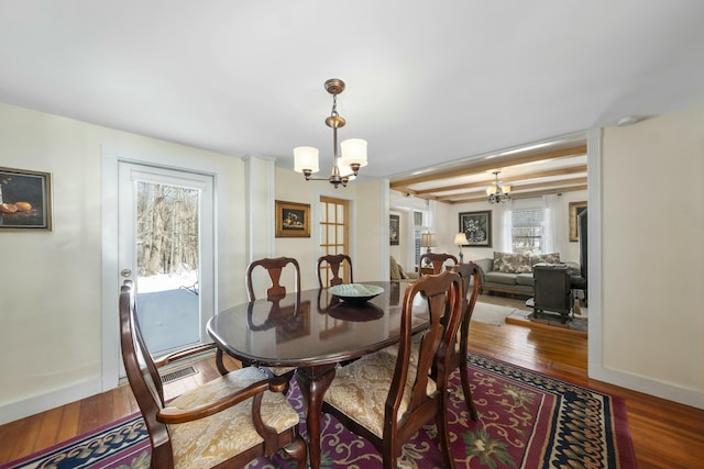 dining room featuring baseboards, dark wood-type flooring, and a notable chandelier