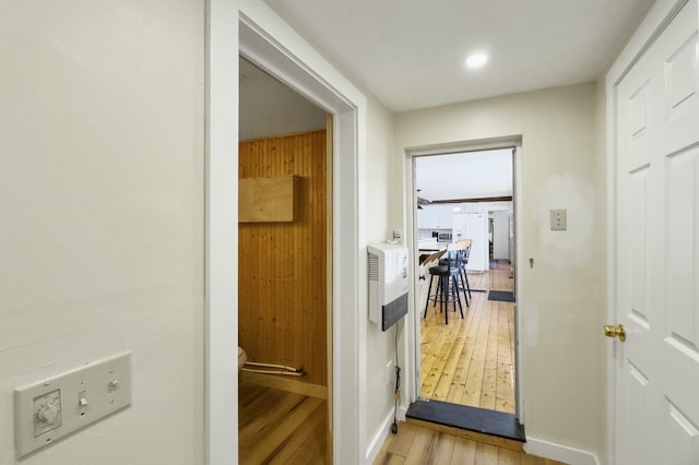 hallway featuring light wood-style flooring and baseboards