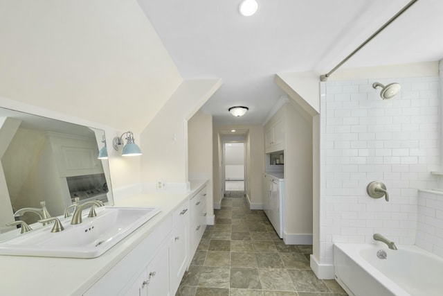 full bath with shower / washtub combination, baseboards, vanity, and washer and clothes dryer