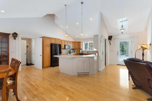 23 Sunny Acres Ln, Boothbay, ME 04537 - kitchen with freestanding refrigerator, stainless steel microwave, light countertops, light wood-style floors, and high vaulted ceiling