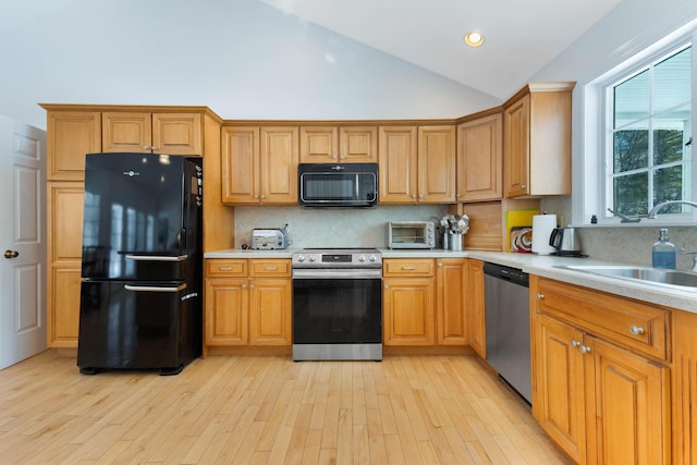 23 Sunny Acres Ln, Boothbay, ME 04537 - kitchen with black appliances, light countertops, lofted ceiling, light wood-type flooring, and tasteful backsplash