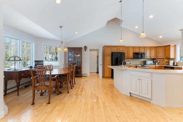23 Sunny Acres Ln, Boothbay, ME 04537 - kitchen with black appliances, light countertops, light wood-style flooring, high vaulted ceiling, and tasteful backsplash