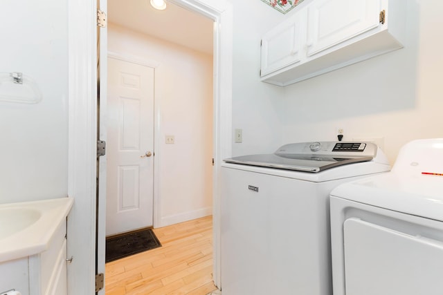 23 Sunny Acres Ln, Boothbay, ME 04537 - laundry area featuring separate washer and dryer, light wood-style floors, cabinet space, and baseboards