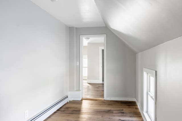 bonus room featuring vaulted ceiling, baseboards, baseboard heating, and dark wood finished floors