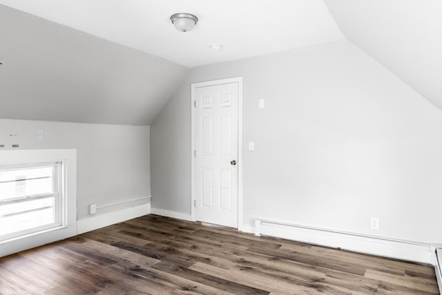 bonus room featuring a baseboard heating unit, lofted ceiling, and dark wood finished floors