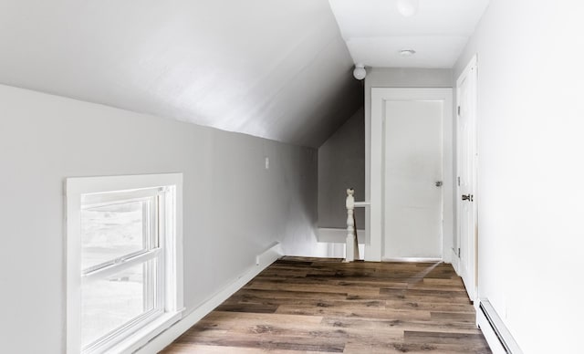 additional living space featuring vaulted ceiling, baseboard heating, and wood finished floors