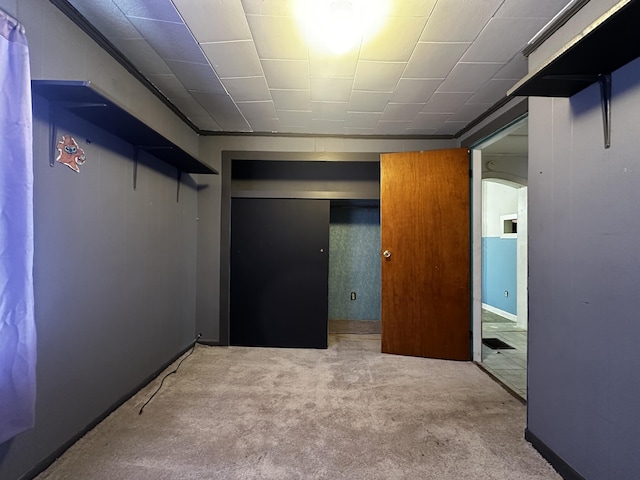 unfurnished bedroom featuring arched walkways and light colored carpet