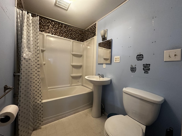 bathroom featuring toilet, a sink, visible vents, tile patterned floors, and shower / bath combo with shower curtain