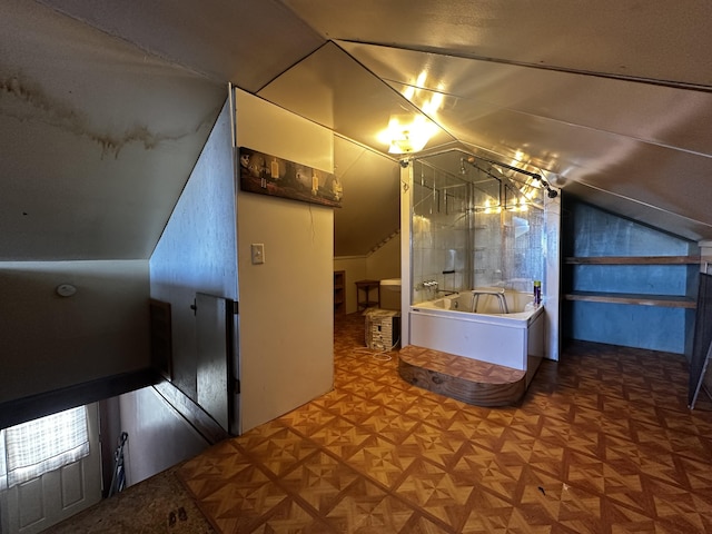 full bath with lofted ceiling and a garden tub