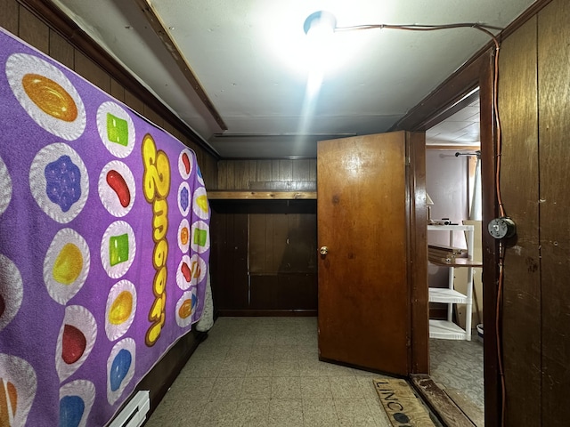 hallway featuring light floors and wooden walls