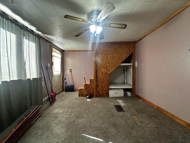 interior space featuring baseboards, visible vents, and ceiling fan