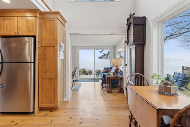 kitchen with freestanding refrigerator, light wood-style floors, and brown cabinets