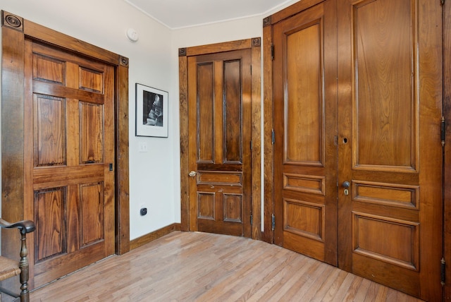 foyer featuring light wood finished floors and baseboards