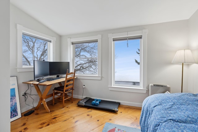 bedroom with hardwood / wood-style flooring, baseboards, lofted ceiling, and an office area