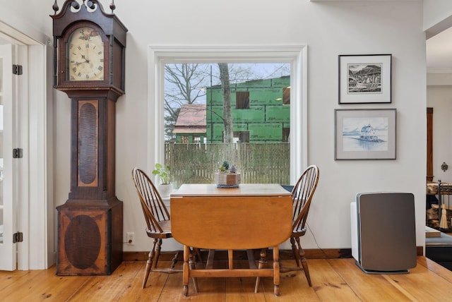 dining space featuring light wood finished floors and baseboards