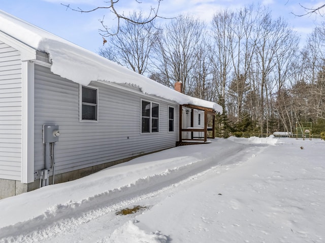 snow covered property featuring a chimney