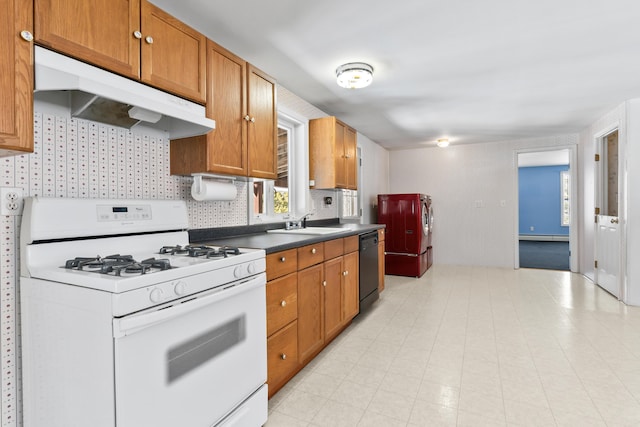 kitchen with dark countertops, brown cabinets, white range with gas cooktop, and under cabinet range hood