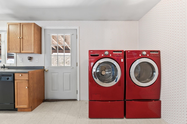 washroom with washing machine and clothes dryer and wallpapered walls