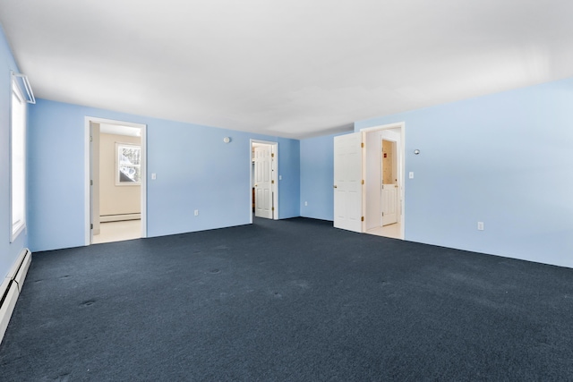 unfurnished room featuring dark colored carpet and a baseboard radiator